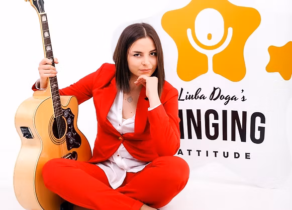 Liuba with guitar during an online coaching session